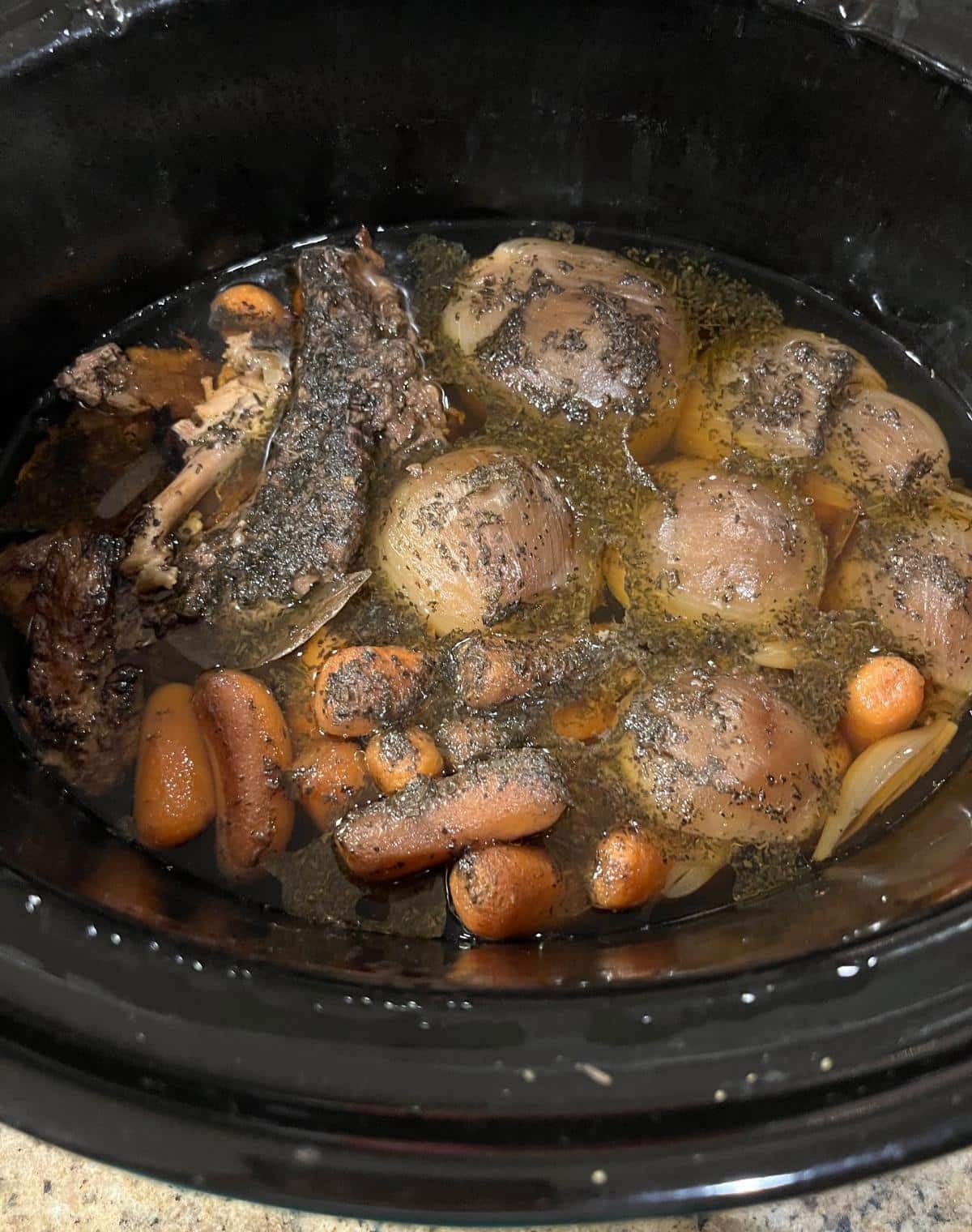 well cooked Bones and Carrots and Onions in Crock Pot