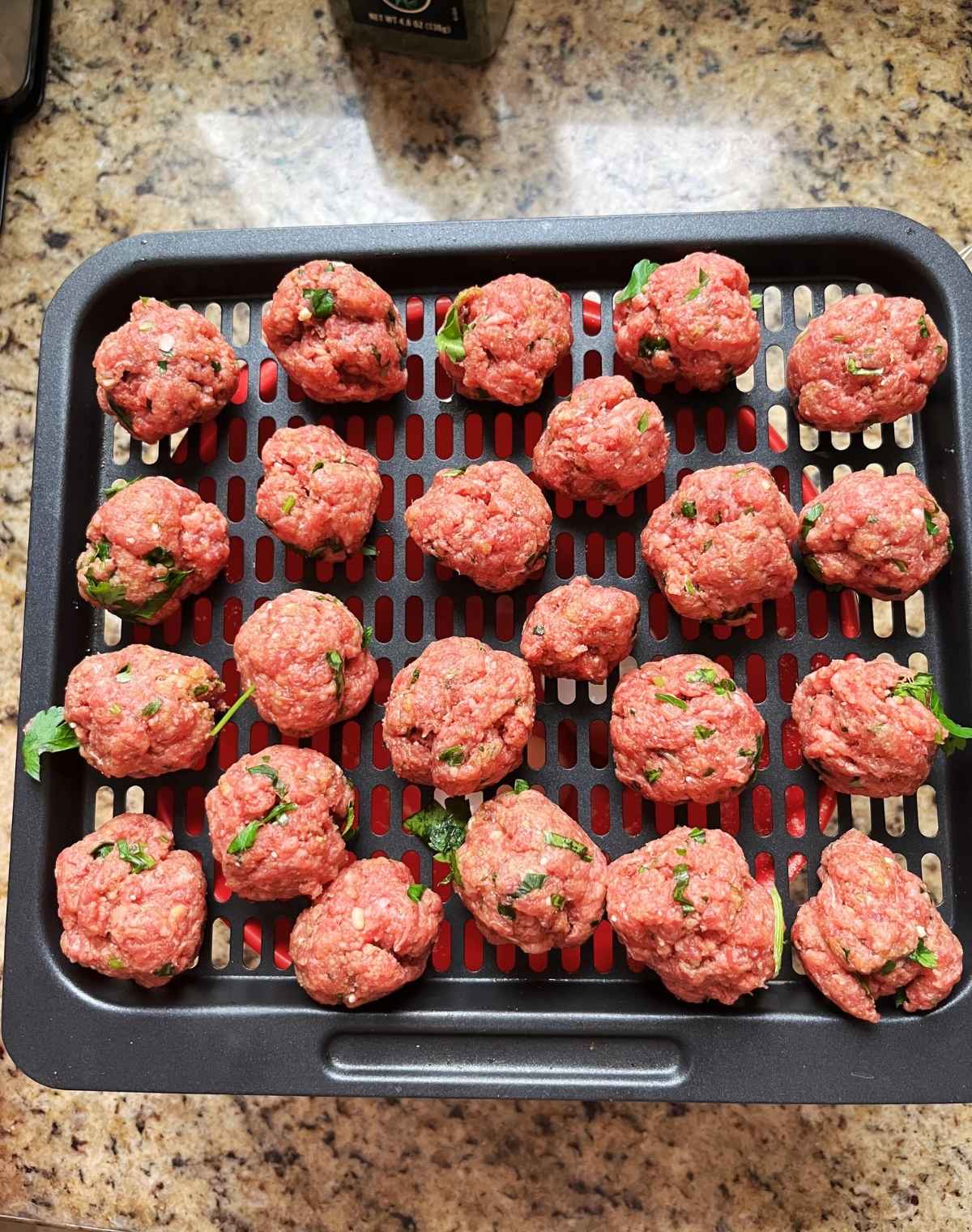 unCooked Bison Meatballs on an air fryer tray