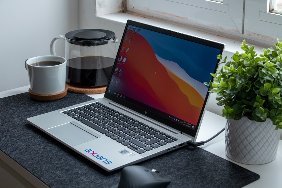 Laptop and white coffee mug on a clean work desk