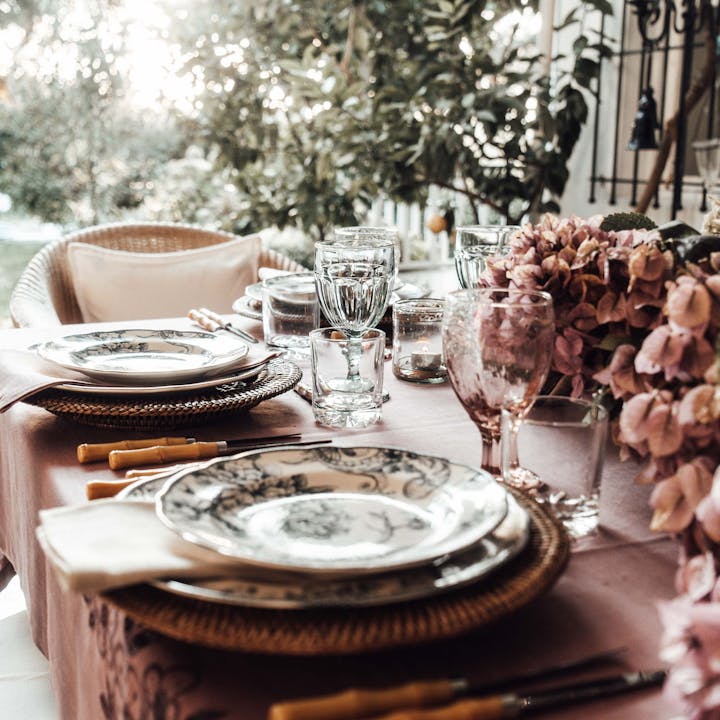 Sophisticated outdoor dining setup featuring floral accents and elegant dishware, perfect for a festive occasion.