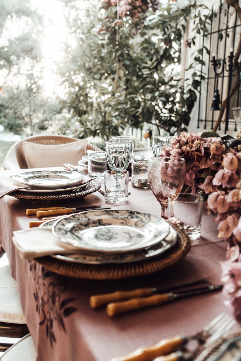 Sophisticated outdoor dining setup featuring floral accents and elegant dishware, perfect for a festive occasion.